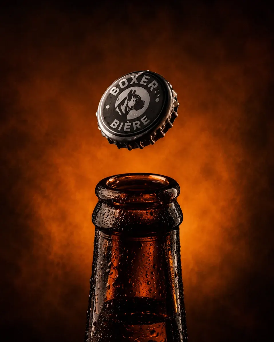 Packshot produit — bouteille de bière Boxer sur fond dramatique