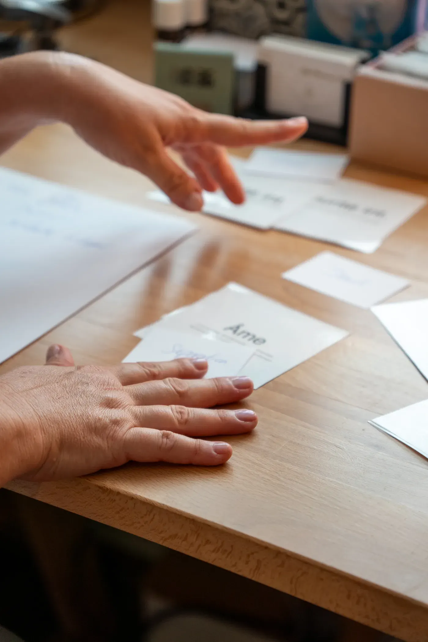 Reportage — deux mains au-dessus de cartes disposées sur une table en bois